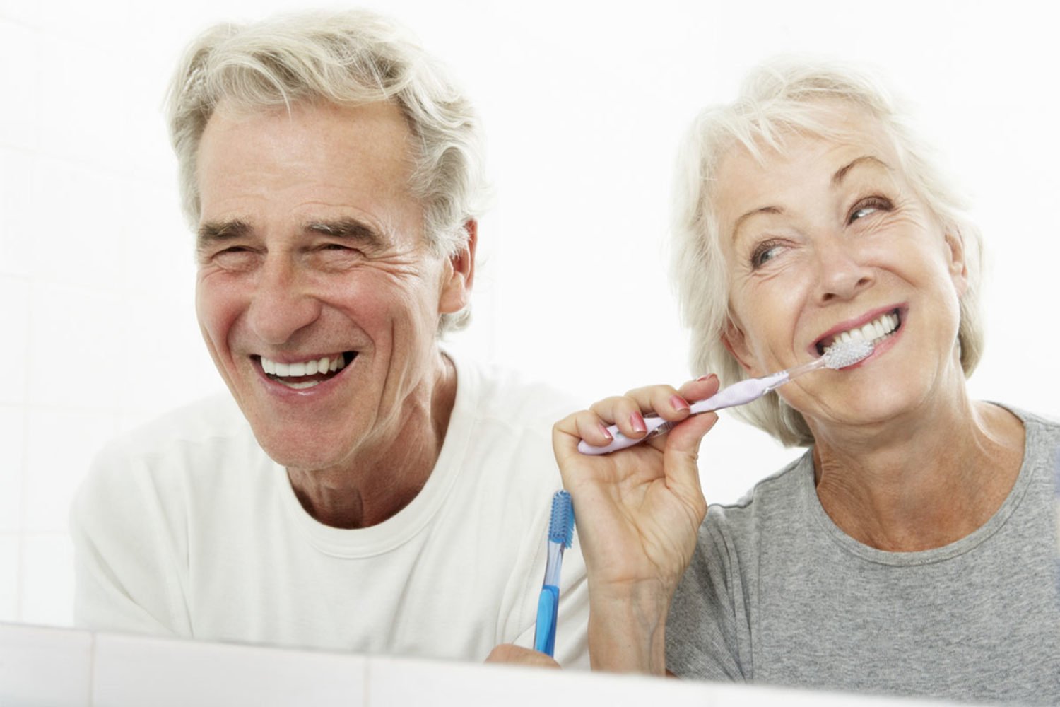Pareja sonriendo gracias a la fijación de su prótesis dental