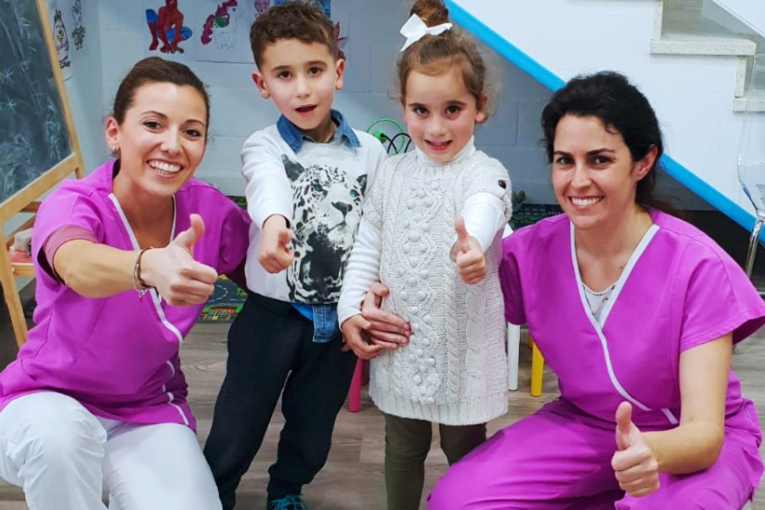Nuestra odontopediatra posando junto a dos niños en clínica dental Implantsite