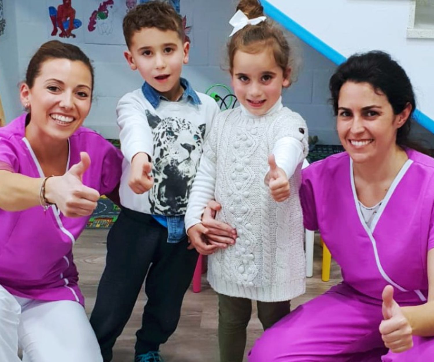 Nuestra odontopediatra posando junto a dos niños en clínica dental Implantsite