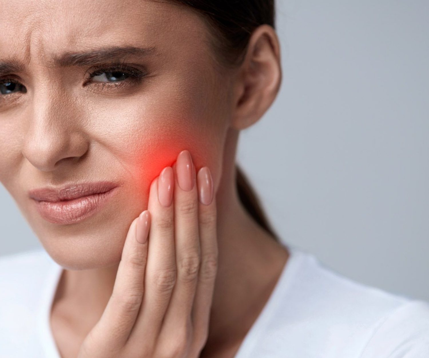 una mujer con dolor causado por la sensibilidad dental