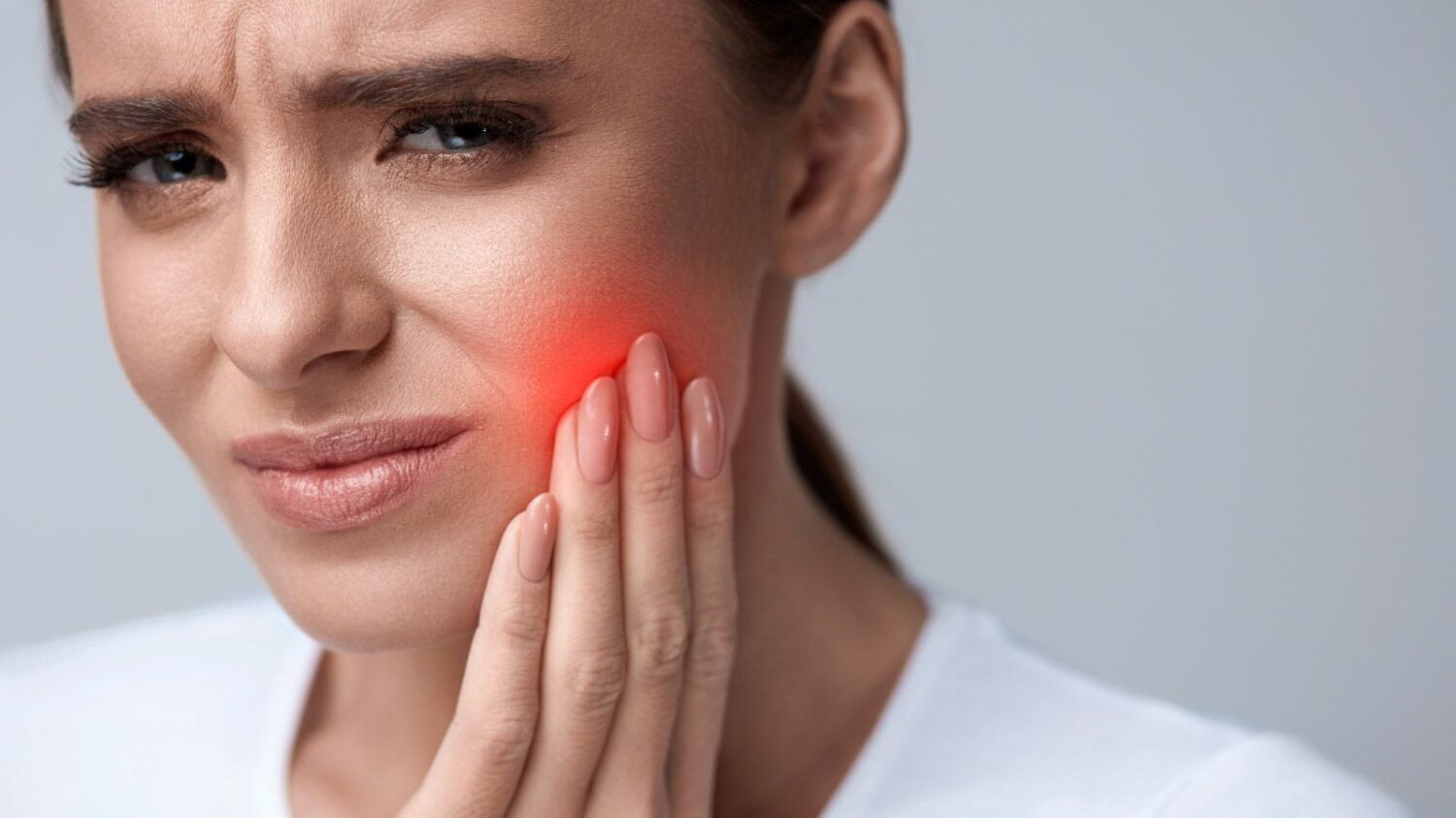 una mujer con dolor causado por la sensibilidad dental