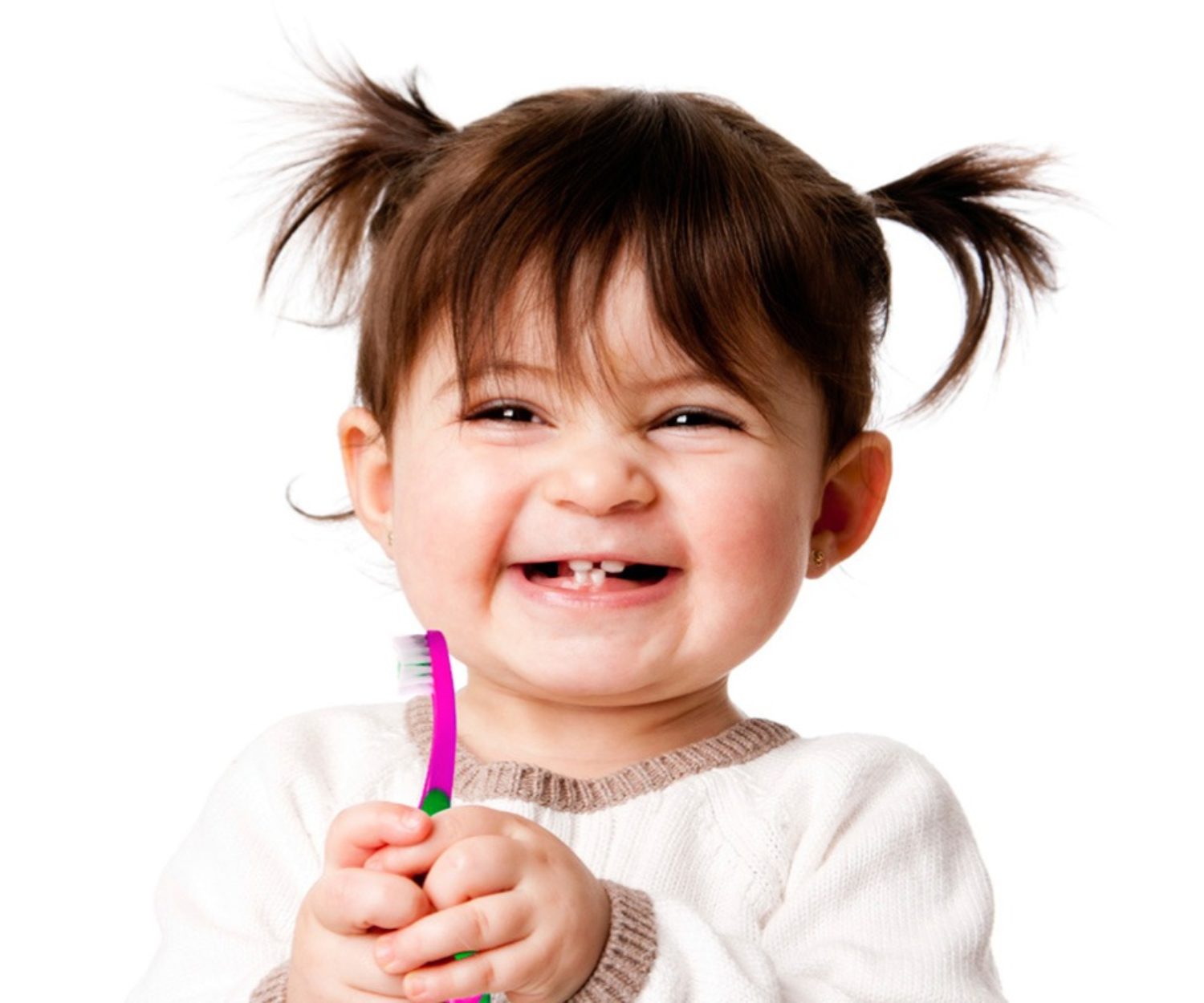 niña pequeña sonríe sujetando un cepillo de dientes