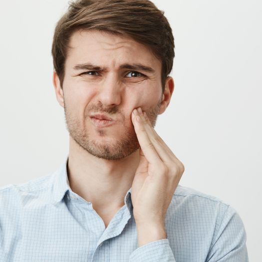 hombre con dolor provocado por las muelas del juicio