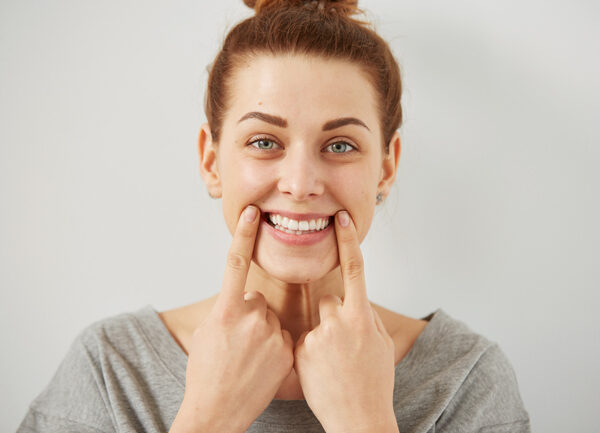 Corona dental para proteger los dientes debilitados por empastes 2 persona feliz con sonrisa estética